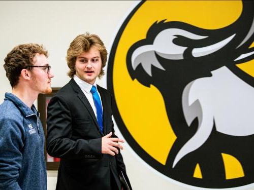 Two students walk together and prep for an interview.