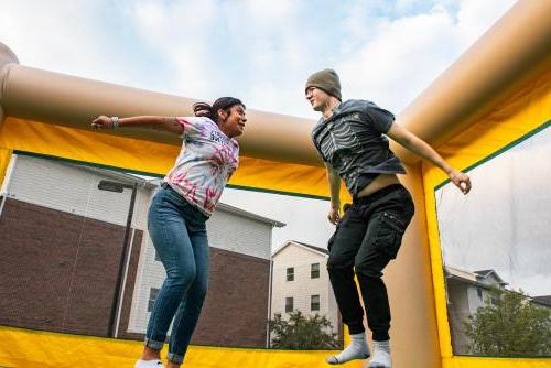 Students jumping in a bounce house at a Student Housing Event.